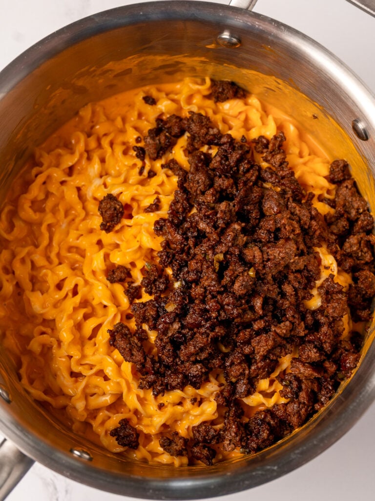 gochujang cottage cheese noodles in a stainless steel pot with a ground beef topping