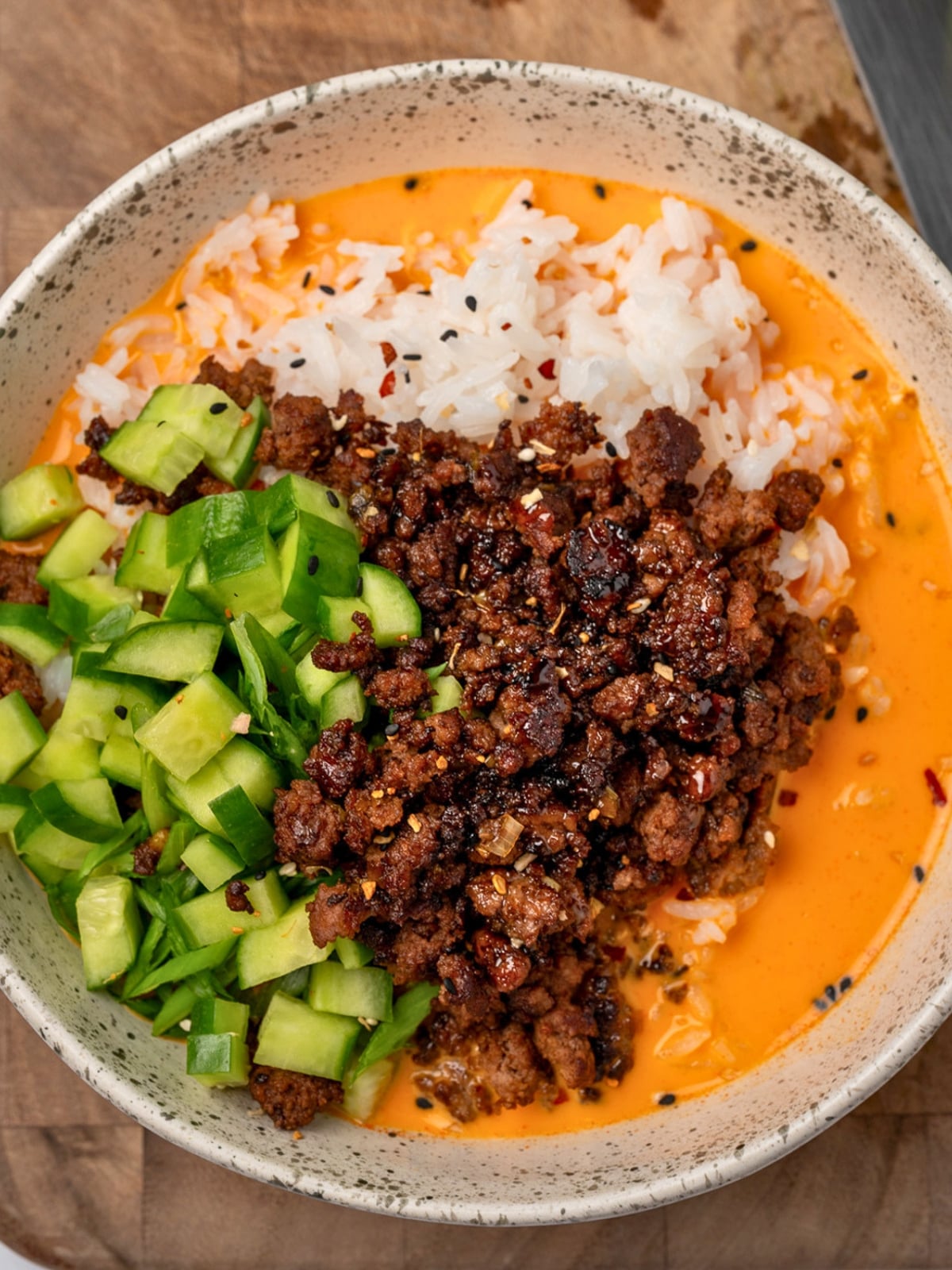 sesame ground beef and rice with creamy gochujang broth and cucumbers