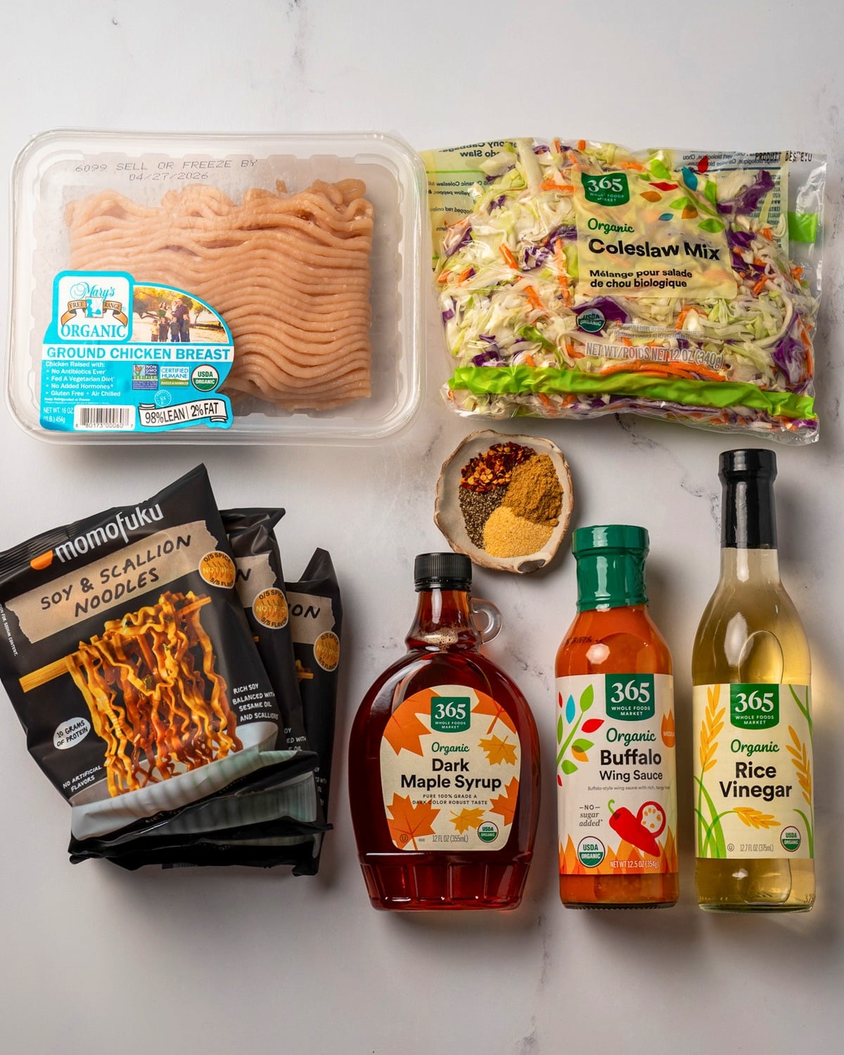 ground chicken breast, coleslaw mix, three packets of Momofuku soy and scallion noodles, dark maple syrup, buffalo sauce, rice vinegar, and a bowl of spices