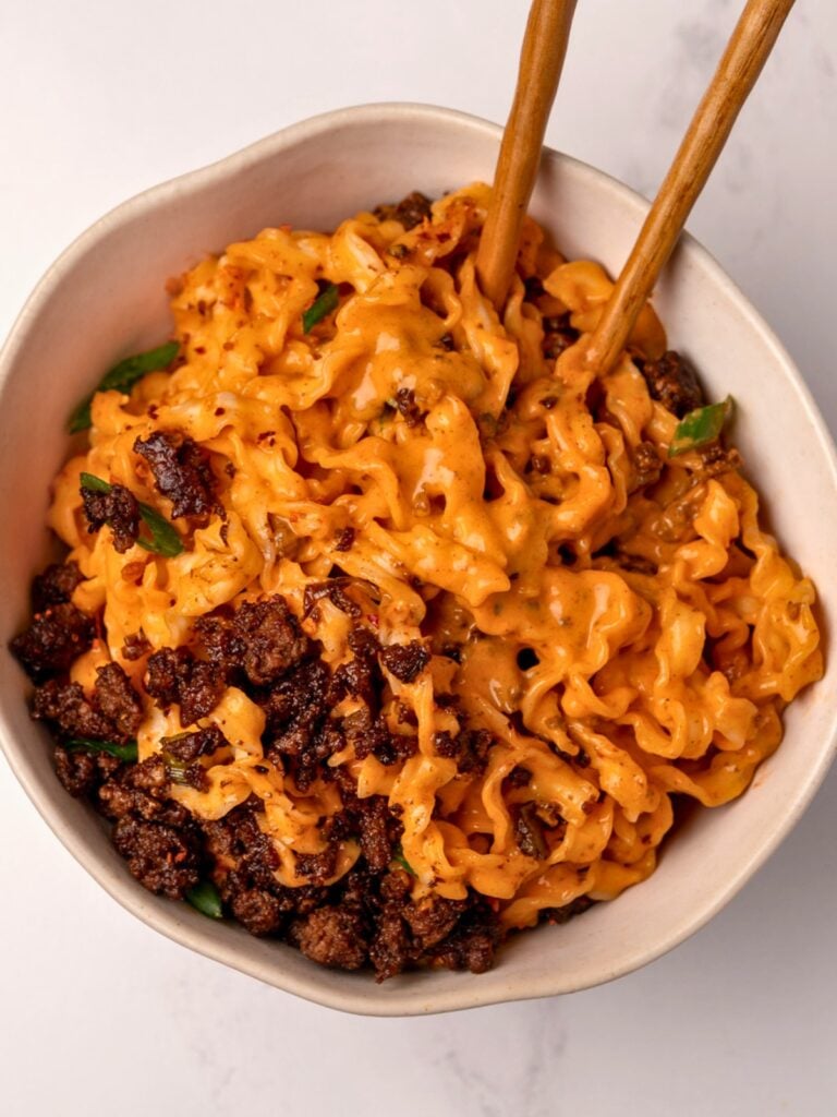 bowl of knife cut noodles in gochujang and cottage cheese sauce with crispy ground beef