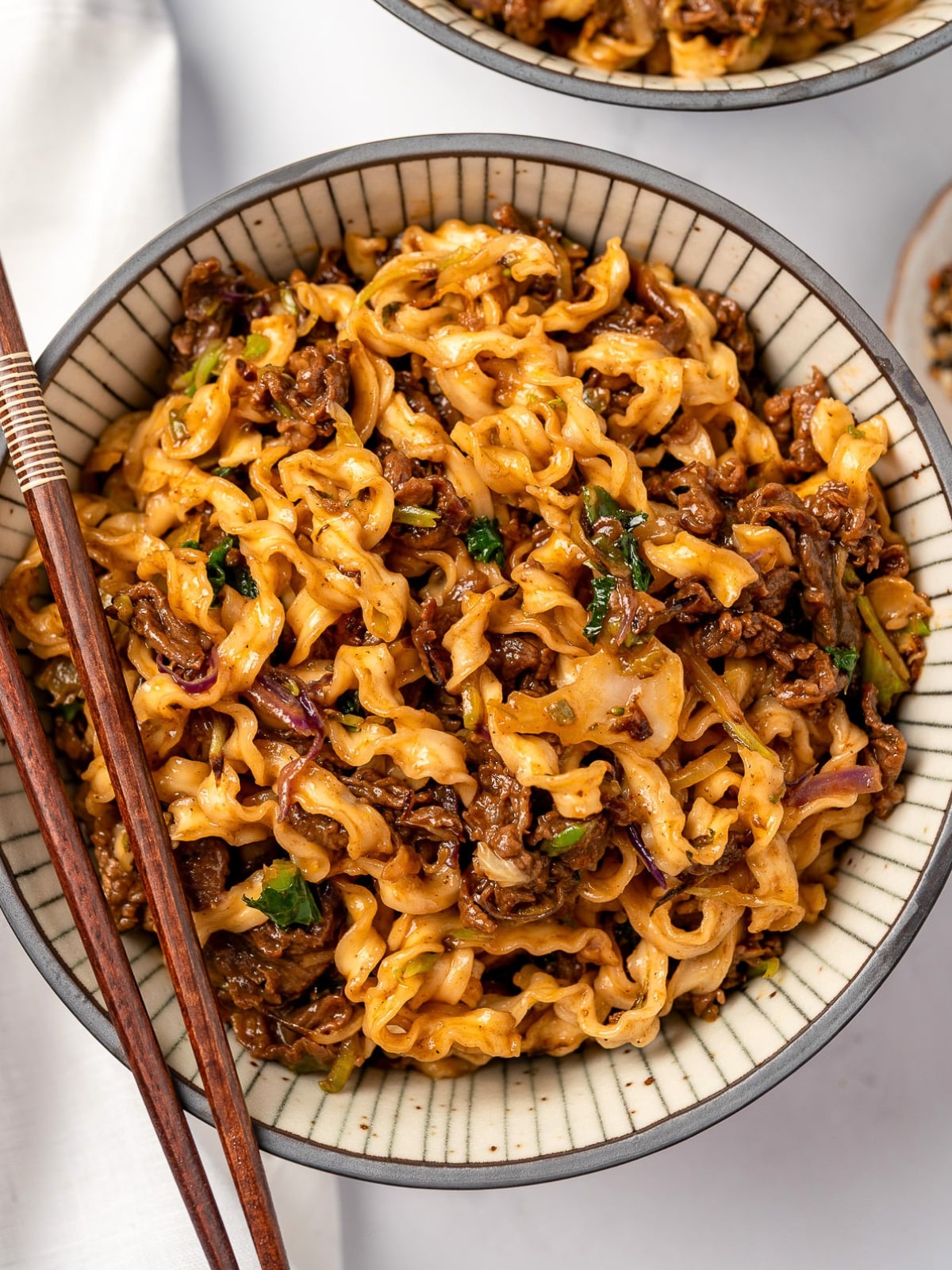 chopsticks on a bowl of beef noodles