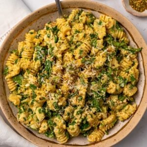 lemon parmesan chicken pasta salad in a bowl garnished with grated parmesan and black pepper