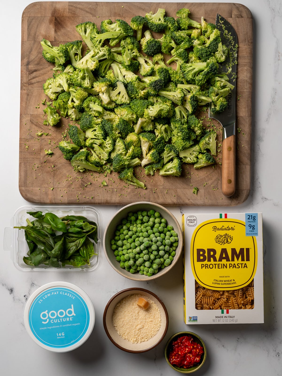 Brami protein pasta, frozen green peas, chopped broccoli, basil, cottage cheese, grated parmesan, and Calabrian chili peppers