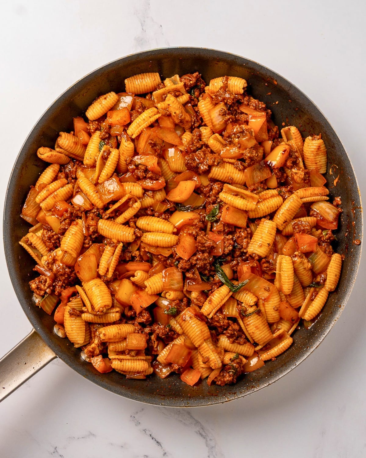beef and bell pepper pasta in a nonstick pan after mixing together