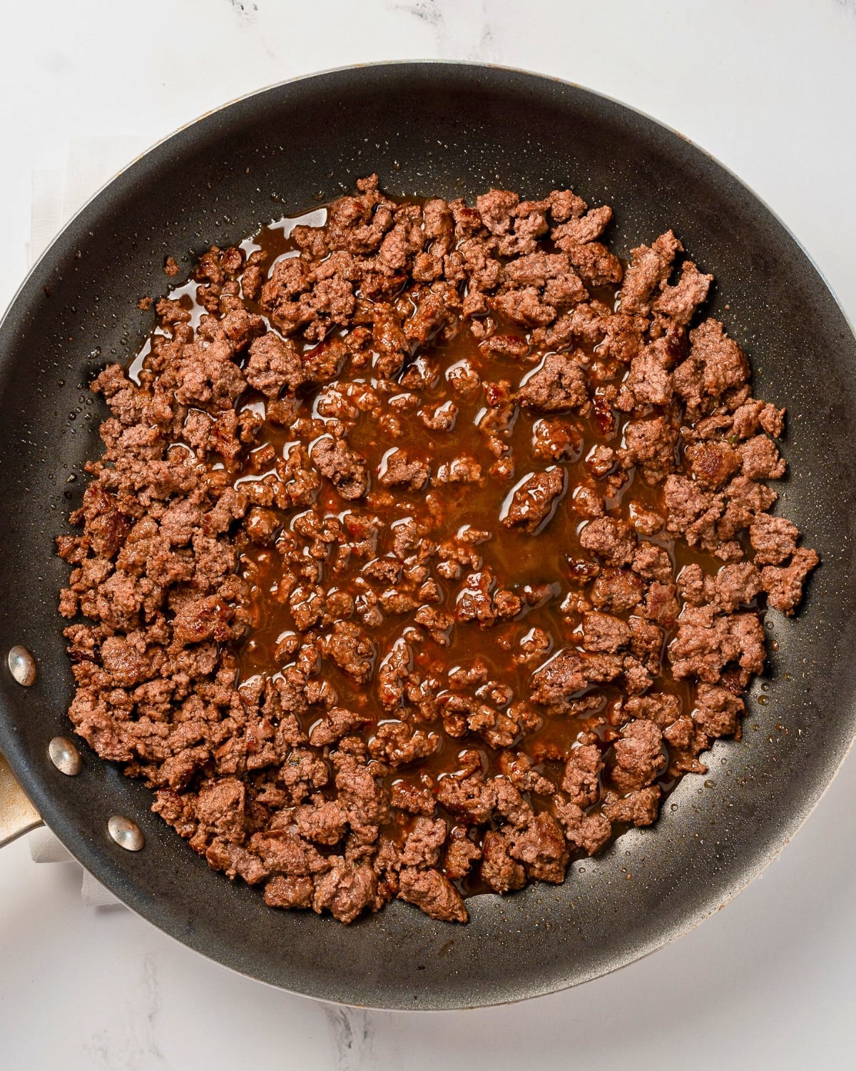 hoisin sauce added to cooked ground beef in a nonstick pan