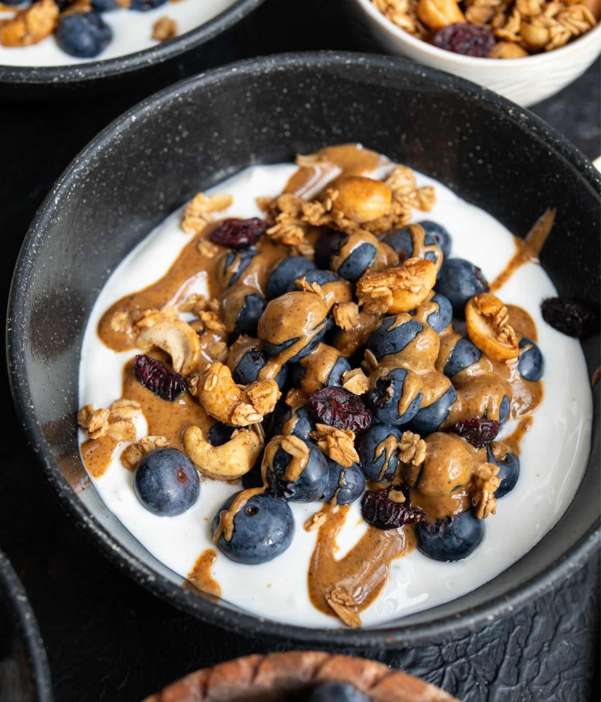 nonfat Greek yogurt topped with fresh blueberries, homemade granola, and an almond butter drizzle