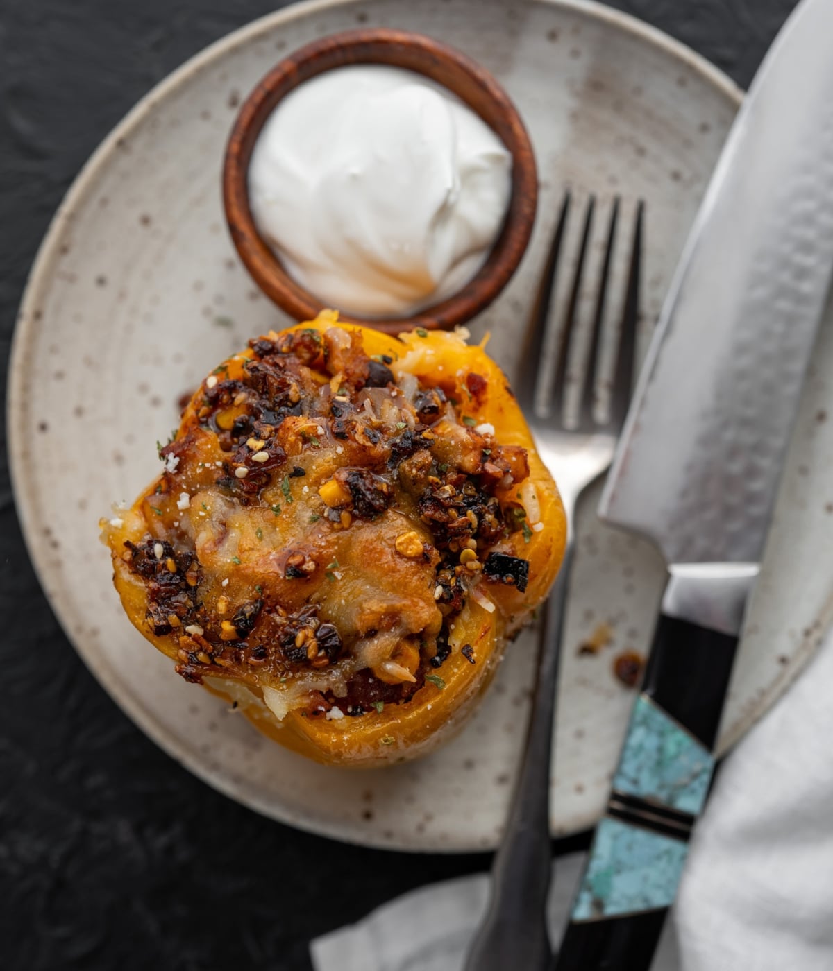 stuffed pepper on a plate with a knife and fork