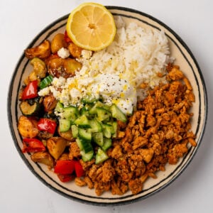 ground chicken and roasted vegetable shawarma bowls topped with cucumber