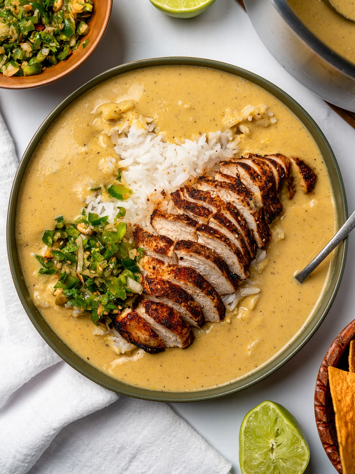 air fried chicken breast slices in a bowl with steamed rice, creamy corn broth, and jalapeño salsa