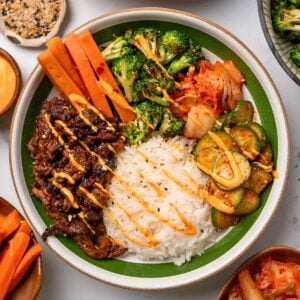 gochujang steak bowls with steak, pickled carrots, cucumbers, roasted broccoli, kimchi, and jasmine rice