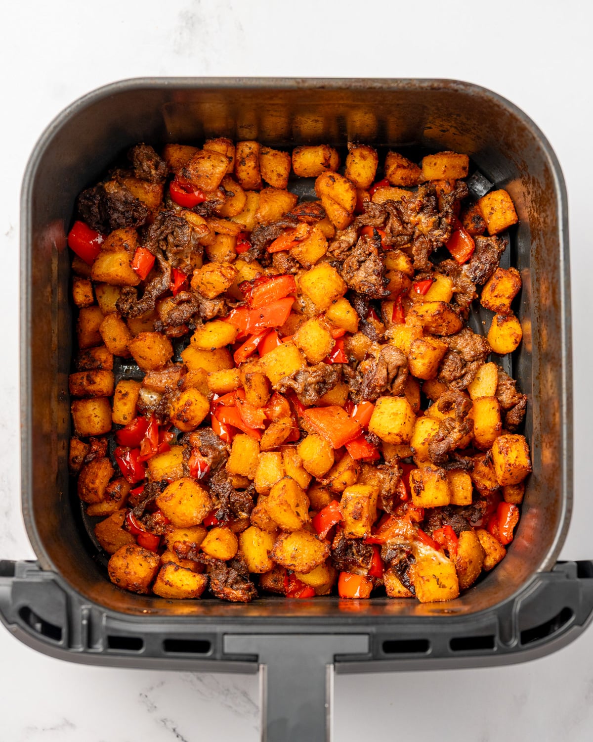 Trader Joe's spicy spuds in an air fryer with leftover sheet pan steak and peppers