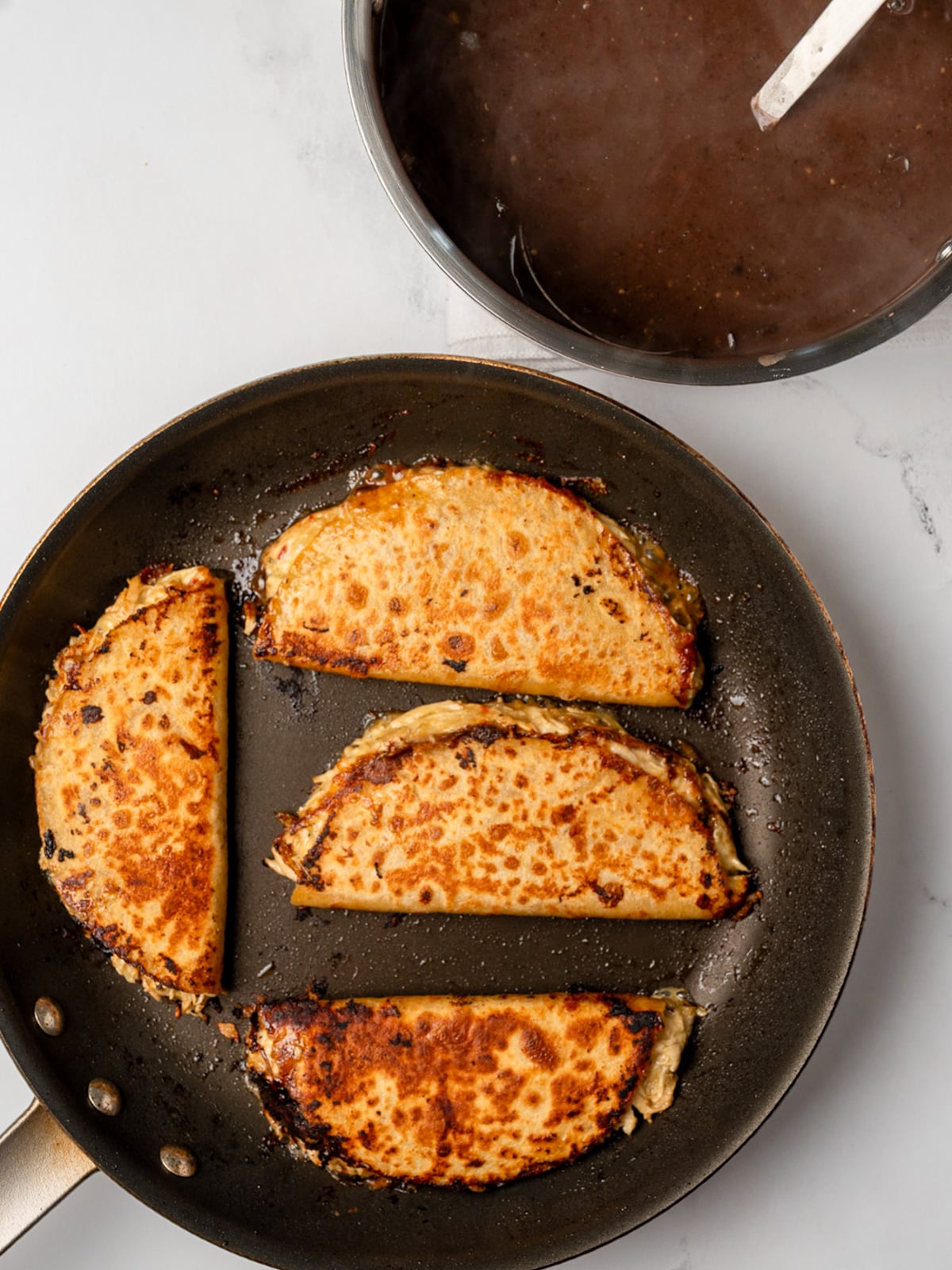 chicken quesadillas in a pan next to a pot of black bean soup