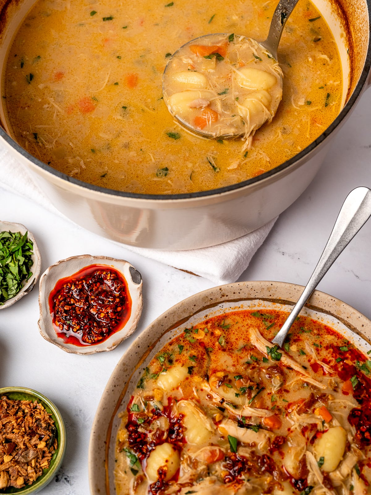 serving chicken gnocchi soup from a Dutch oven