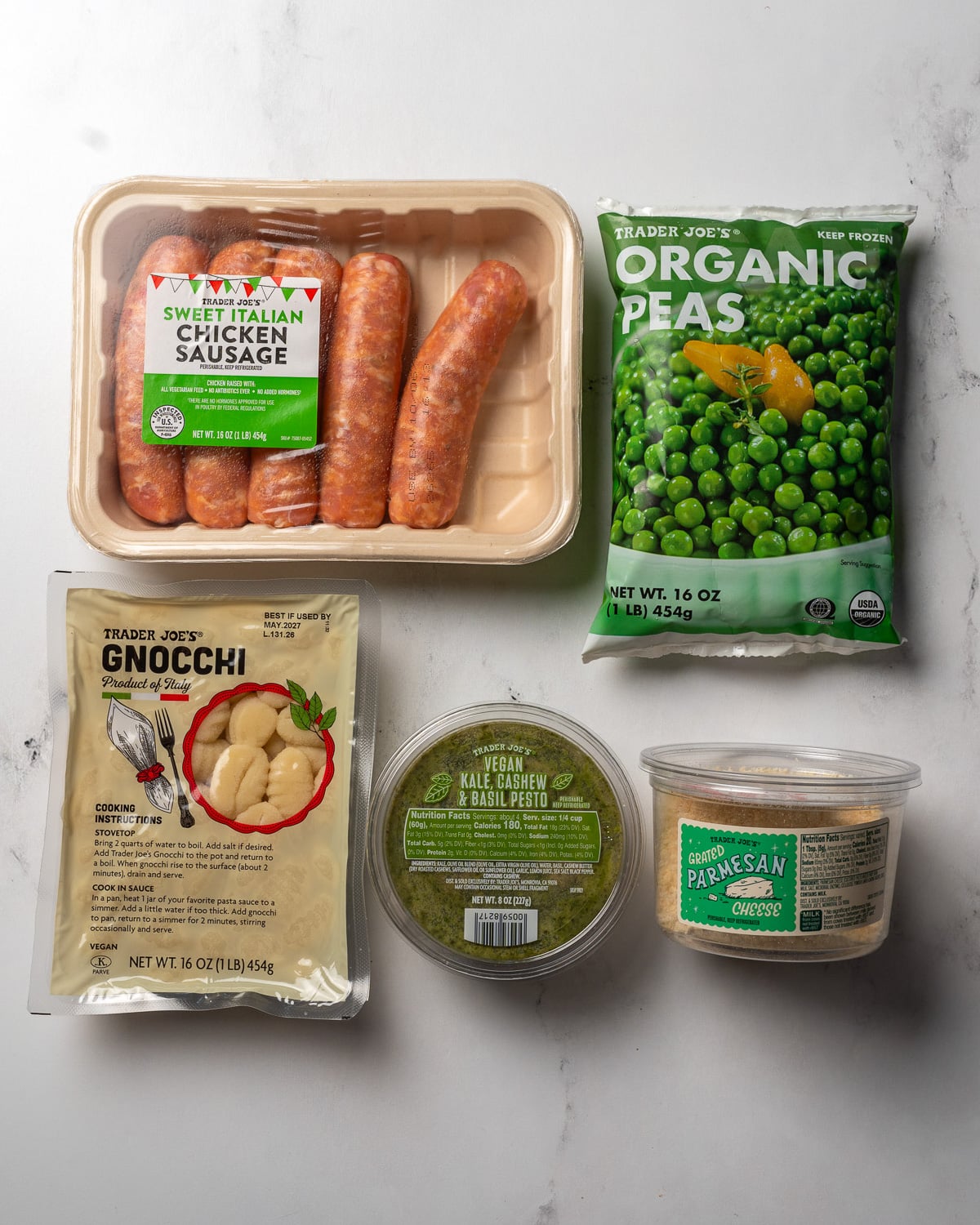 Trader Joe's sweet Italian chicken sausage, frozen peas, potato gnocchi, cashew and kale pesto, and grated parmesan