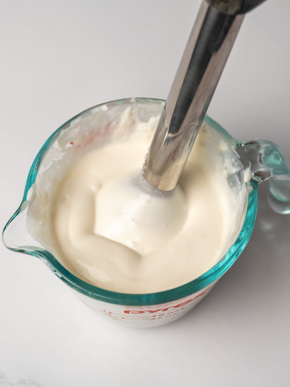 blending honey, goat cheese, and cottage cheese together in a measuring cup with an immersion blender