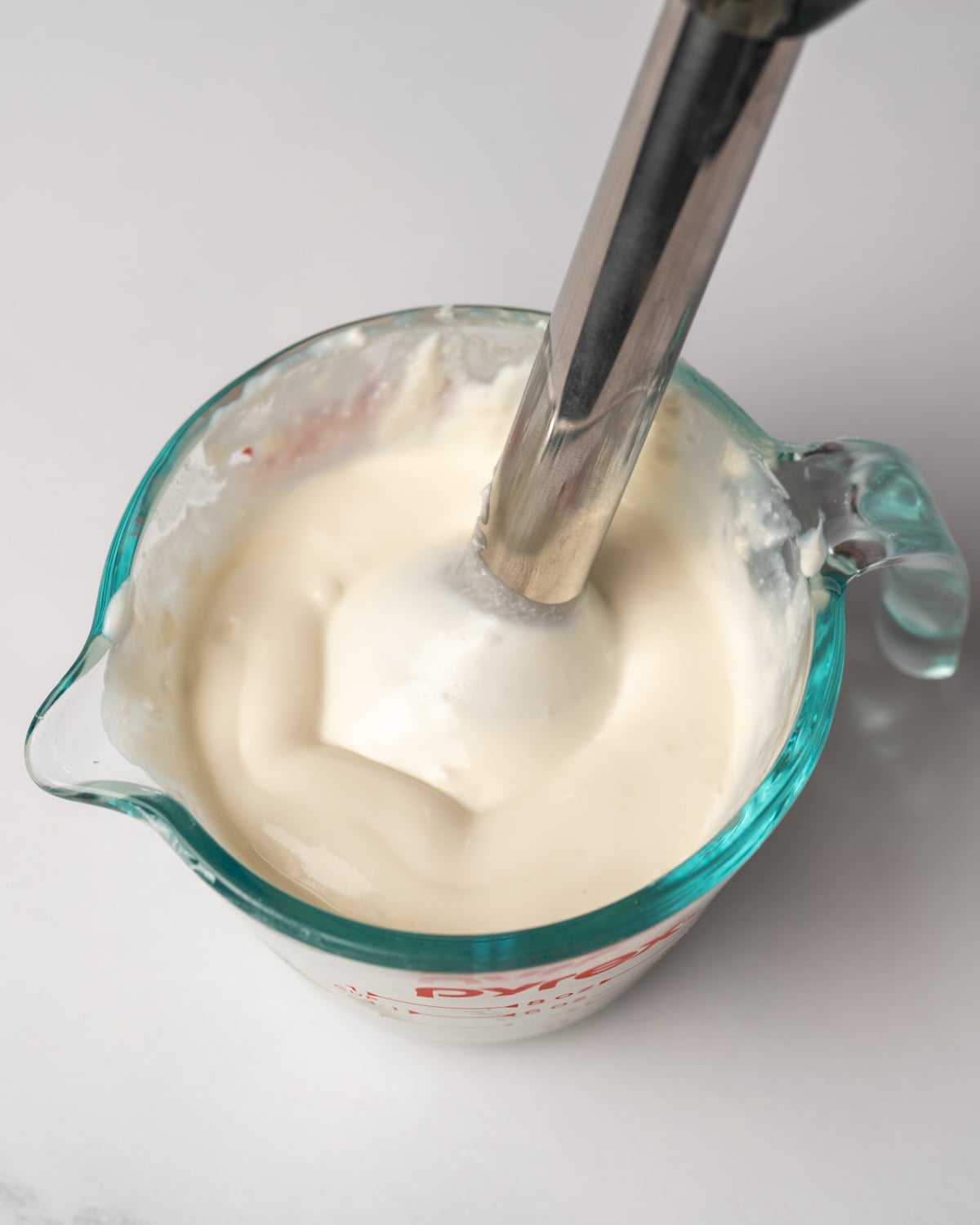 whipping goat cheese with cottage cheese and honey in a mixing glass