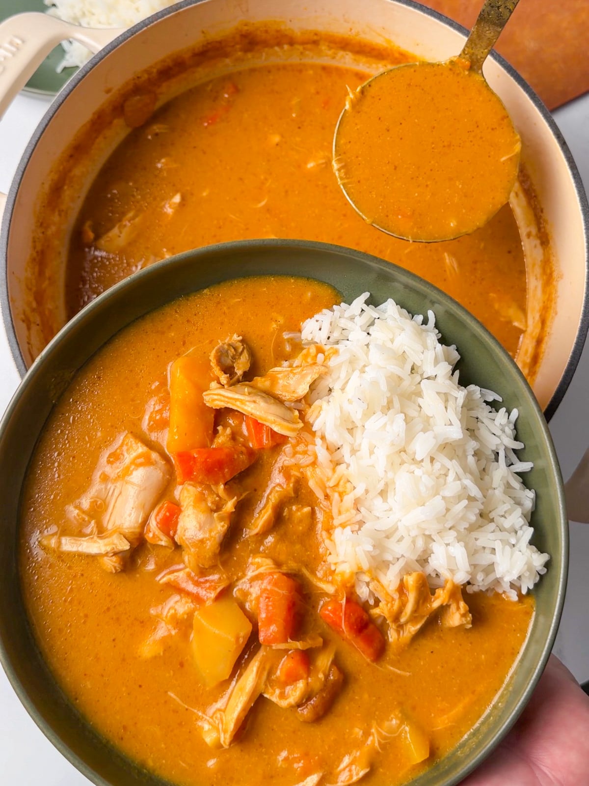 plating pumpkin curry in a bowl with steamed jasmine rice