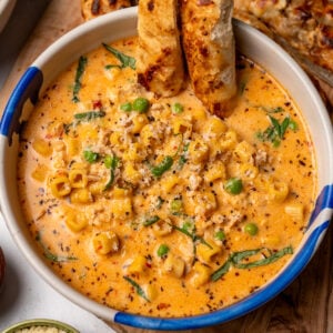 crispy onion focaccia in a bowl of cheesy Italian chicken soup garnished with basil and parmesan cheese