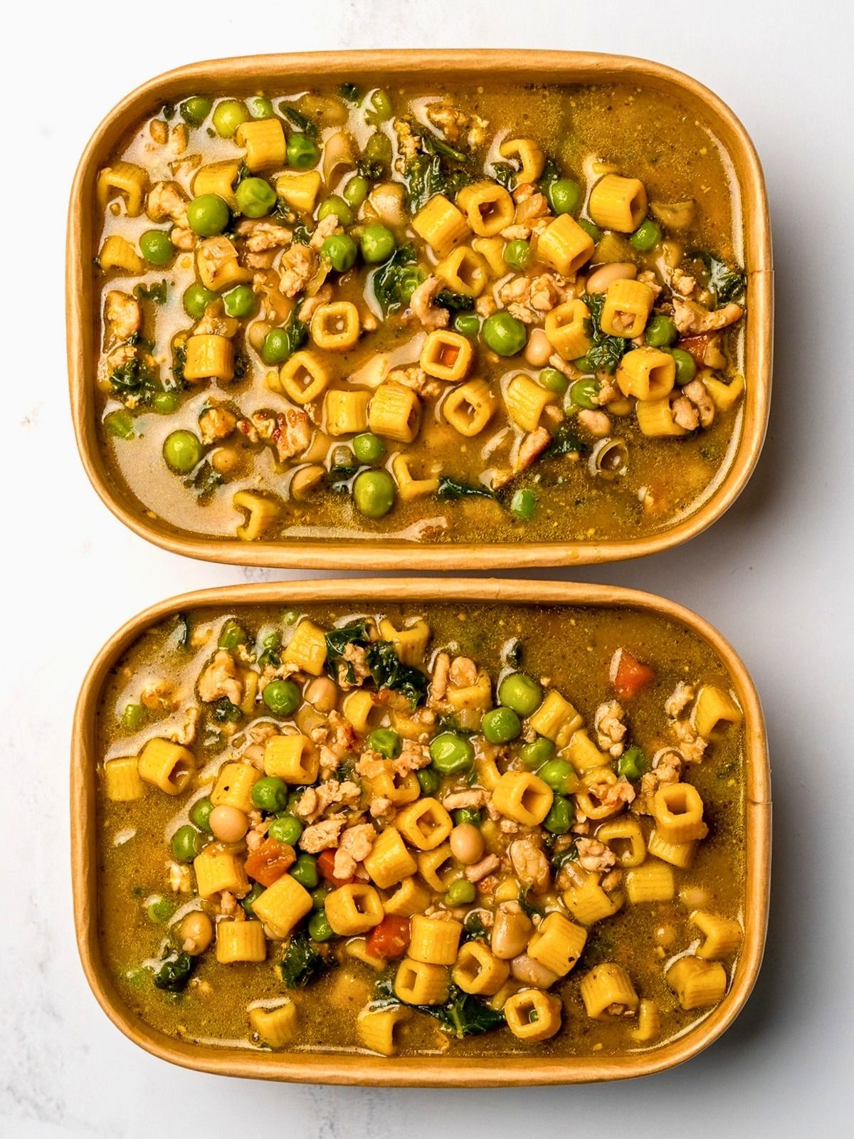 two meal prep containers with chicken soup