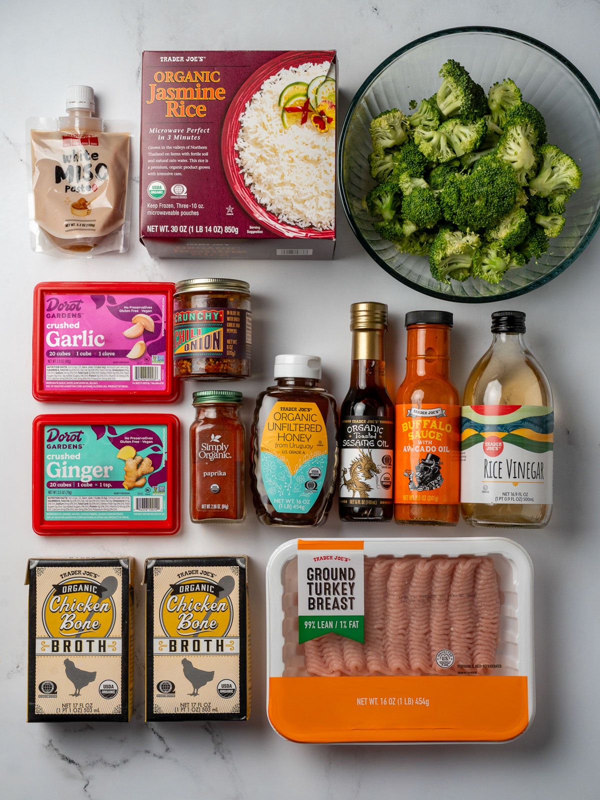 white miso paste, frozen steamed jasmine rice, broccoli florets, frozen crushed garlic and ginger, paprika, crispy chili onion, honey, toasted sesame oil, buffalo sauce, rice vinegar, ground turkey, and chicken bone broth from Trader Joe's