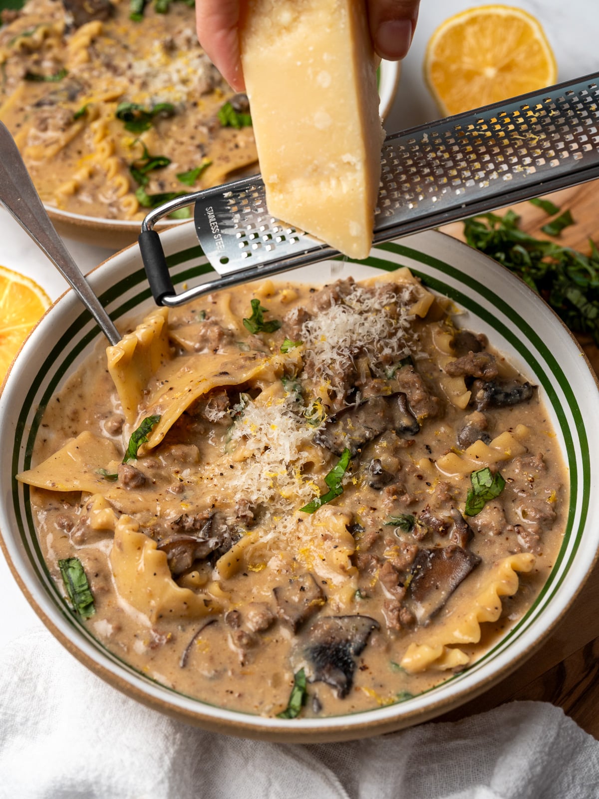 grating parmesan over bowls of lasagna soup