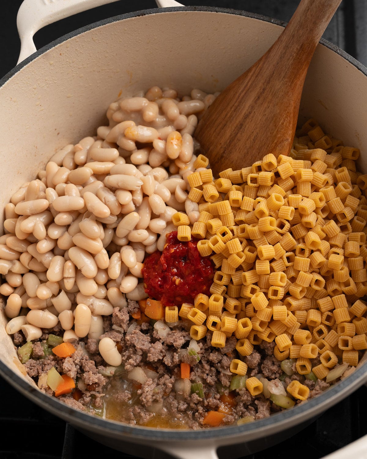 cooked ground beef and mirepoix with white beans, Calabrian chili peppers, and protein pasta added