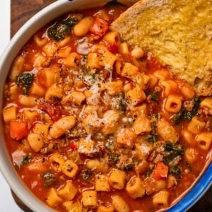 a bowl of high protein pasta fagioli with a slice of toasted sourdough bread